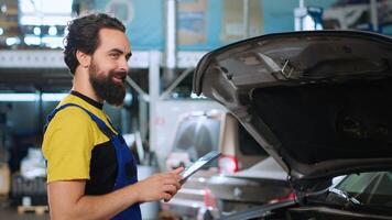 ritratto di esperto tecnico nel auto riparazione negozio fare auto annuale verifica utilizzando tavoletta, guardare per danni. riparatore a opera controllo per vedere Se veicolo componenti bisogno per essere cambiato, vicino su foto