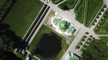 superiore Visualizza di vecchio tenuta con giardino e stagno. creativo. bellissimo giardino la zona con modelli di percorsi e stagno su soleggiato estate giorno. persone camminare nel reale giardino su tenuta foto