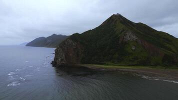 superiore Visualizza di sorprendente paesaggio di montagna costa su nuvoloso giorno. clip. cinematico paesaggio di costa con roccioso verde montagne. bellissimo mare via costa di montagnoso nord isola foto