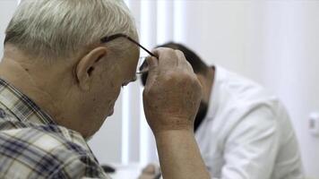 maschio medico Lavorando a il tavolo, scrittura prescrizione. clip. vecchio maschio paziente a il Ospedale. foto