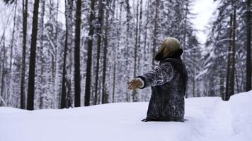 contento giovane uomo nel fiaba inverno foresta preghiere per Dio in piedi su il suo ginocchia. media. concetto di religione e sensazione unità con natura. foto