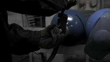 vicino su di lavoratore nel guanti svolta gas cilindro valvola. clip. industriale sfondo di il fabbrica. foto