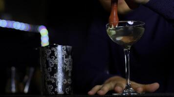 un' professionale barista preparazione un alcolizzato cocktail con crema guarnizione. media. fabbricazione un' bevanda a il bar o discoteca club. foto
