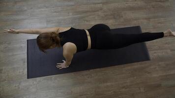 bellissimo sportivo ragazza praticante yoga o pilates a casa. media. superiore Visualizza di un' donna fare equilibrio esercizio e allungamento sua braccio e gamba. foto