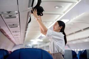 asiatico giovane donna d'affari riuscito nel il aereo o imprenditore nel un' attività commerciale classe posto a sedere durante volo. in viaggio e attività commerciale concetto foto
