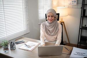 asiatico musulmano donna d'affari nel hijab testa sciarpa Lavorando con carta documento nel il moderno ufficio. diversità e ufficio concetto foto