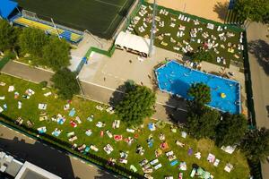 superiore Visualizza di un all'aperto posto per persone per rilassare dove Là è un' nuoto piscina e un' lotto di sole letti foto