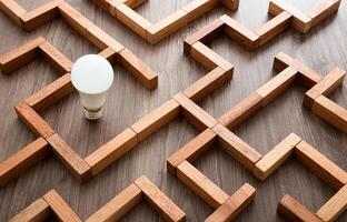 leggero lampadina nel il labirinto gioco costruito di legna blocchi, scoperta il giusto modo per il successo, idea concetto foto