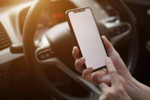 Telefono nel macchina, mano utilizzando smartphone su auto foto