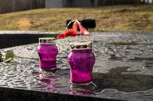 lampade per un' monumento, candelieri per candele In piedi su un' marmo piedistallo dopo pioggia su il strada foto