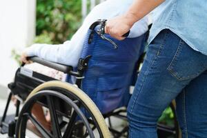 badante Aiuto asiatico anziano donna invalidità paziente seduta su sedia a rotelle nel Ospedale, medico concetto. foto