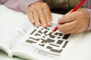 anziano donna giocando sudoku puzzle gioco per trattamento demenza prevenzione e alzheimer patologia. foto