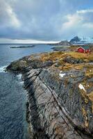 clif con tradizionale rosso rorbu Casa su lofoten isole, Norvegia foto