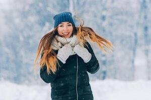 inverno giovane donna ritratto. bellezza gioioso modello ragazza ridendo e avendo divertimento nel inverno parco. bellissimo giovane donna all'aperto. godendo natura, orario invernale foto