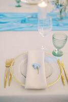 blu delfinio fiore bugie su un' tovagliolo su un' piatto su un' impostato tavolo foto