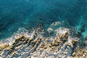 mare onde lavare il aspro roccioso costa. fuco foto