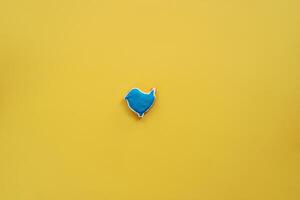 smaltato blu Pan di zenzero uccello bugie nel il centro su un' giallo sfondo foto