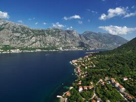 ricorrere cittadina su il sponde di il baia di kotor tra verde alberi a il piede di il montagne. montenegro. fuco foto