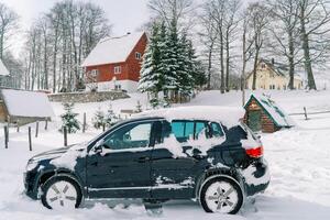 innevato suv sta vicino un' di legno capannone nel il villaggio foto