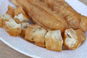 vicino su di tagliare cakoi o youtiao su bianca piatto. asiatico cibo concetto foto