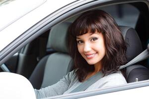 bella donna autista sorridente per voi a partire dal il bianca auto foto