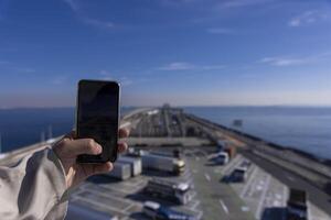 un' traffico marmellata tiro di smartphone su il autostrada a tokyo baia la zona nel chiba foto