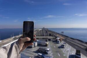 un' traffico marmellata tiro di smartphone su il autostrada a tokyo baia la zona nel chiba foto