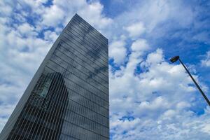 un' nube riflettendo il edificio nel il attività commerciale cittadina largo tiro foto