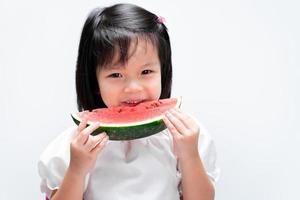 ragazza felice del bambino che mangia anguria. cibo sano per bambini. concetto di frutta estiva. foto