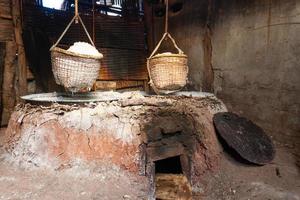 Immagine della produzione di salgemma naturale mediante bollitura di soluzione salina dal laghetto di sale di Sinthao nel piccolo villaggio di Nan, Thailandia foto