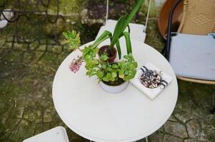 superiore Visualizza portacenere con sigaretta mozziconi su il bianca tavolo con sedia nel il giardino. il concetto di polmone cancro malattie foto