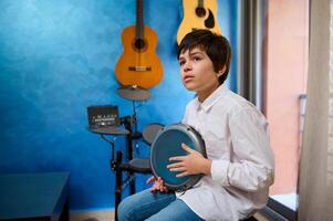 caucasico bello bambino ragazzo, batterista musicista giocando batteria, la creazione di ritmo di musica, godendo il etnico africano tradizionale cultura foto