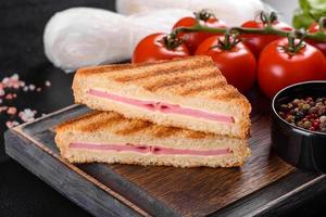 panino con prosciutto, formaggio, pomodori, lattuga e pane tostato foto