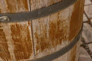 avvicinamento di il struttura di un vecchio antico vino botte. di legno barile con metallo arrugginito cinghie modello sfondo foto