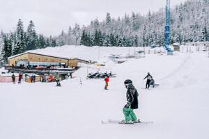 sciatore sciare su un' nevoso pendenza vicino il Hotel foto