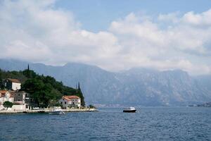 motoscafi siamo ormeggiato via il costa di perast con vecchio case con rosso tetti. montenegro foto