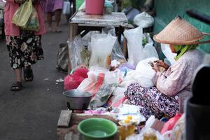un' commerciante a un' tradizionale mercato è conteggio il i soldi a partire dal il suo i saldi foto