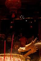 ardente preghiera bastoni riempire il camera con ondeggiante Fumo con Drago decorazioni su il lati a il Cinese nuovo anno celebrazione. ita un kong tempio, malang, Indonesia foto