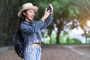 giovane donna asiatica esplora la foresta in vacanza foto
