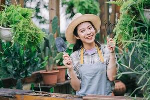 giovane donna asiatica si prende cura del giardino foto