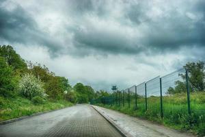 la strada è asfaltata lungo l'area recintata e le torri di confine foto