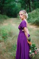 ragazza modella bionda in un abito lilla con un bouquet foto
