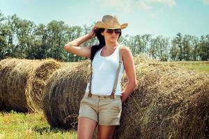 ragazza con i capelli neri in cappotti di lana beige sta vicino ai pagliai foto