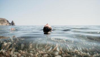 donna nuoto nel mare a tramonto, galleggiante su calma acqua indietro Visualizza. concetto di corpo Immagine e fitness, godendo un' sereno spiaggia. contento donna con Perfetto in forma corpo gode mare spiaggia foto