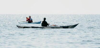 uomo donna mare kayak. contento gratuito uomo e donna nel kayak su oceano, paddling con di legno remo. calma mare acqua e orizzonte nel sfondo. attivo stile di vita a mare. estate vacanza. foto