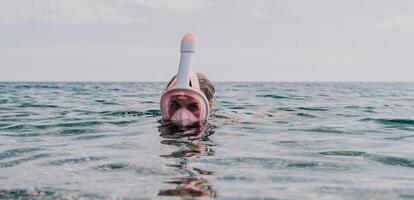 giovane contento donna nel bianca bikini e indossare rosa maschera prende pronto per mare snorkeling. positivo sorridente donna rilassante e godendo acqua attività con famiglia estate viaggio vacanze vacanza su mare. foto