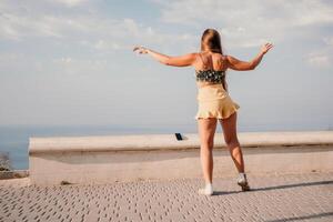 donna estate danza. silhouette di un' contento donna chi balli, gira e solleva sua mani per il cielo. un' giocoso giovane donna gode sua contento momento danza nel il raggi di il d'oro sole. foto