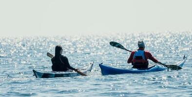 uomo donna mare kayak. contento gratuito uomo e donna nel kayak su oceano, paddling con di legno remo. calma mare acqua e orizzonte nel sfondo. attivo stile di vita a mare. estate vacanza. foto