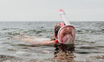 giovane contento donna nel bianca bikini e indossare rosa maschera prende pronto per mare snorkeling. positivo sorridente donna rilassante e godendo acqua attività con famiglia estate viaggio vacanze vacanza su mare. foto