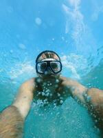 nuotatore nel occhiali immersioni sotto il acqua, raccolta spruzzi foto